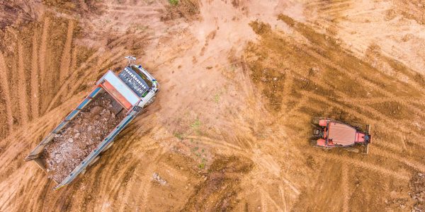 Dump truck unloads soil on the construction site. Dump truck unloads soil on the construction site.